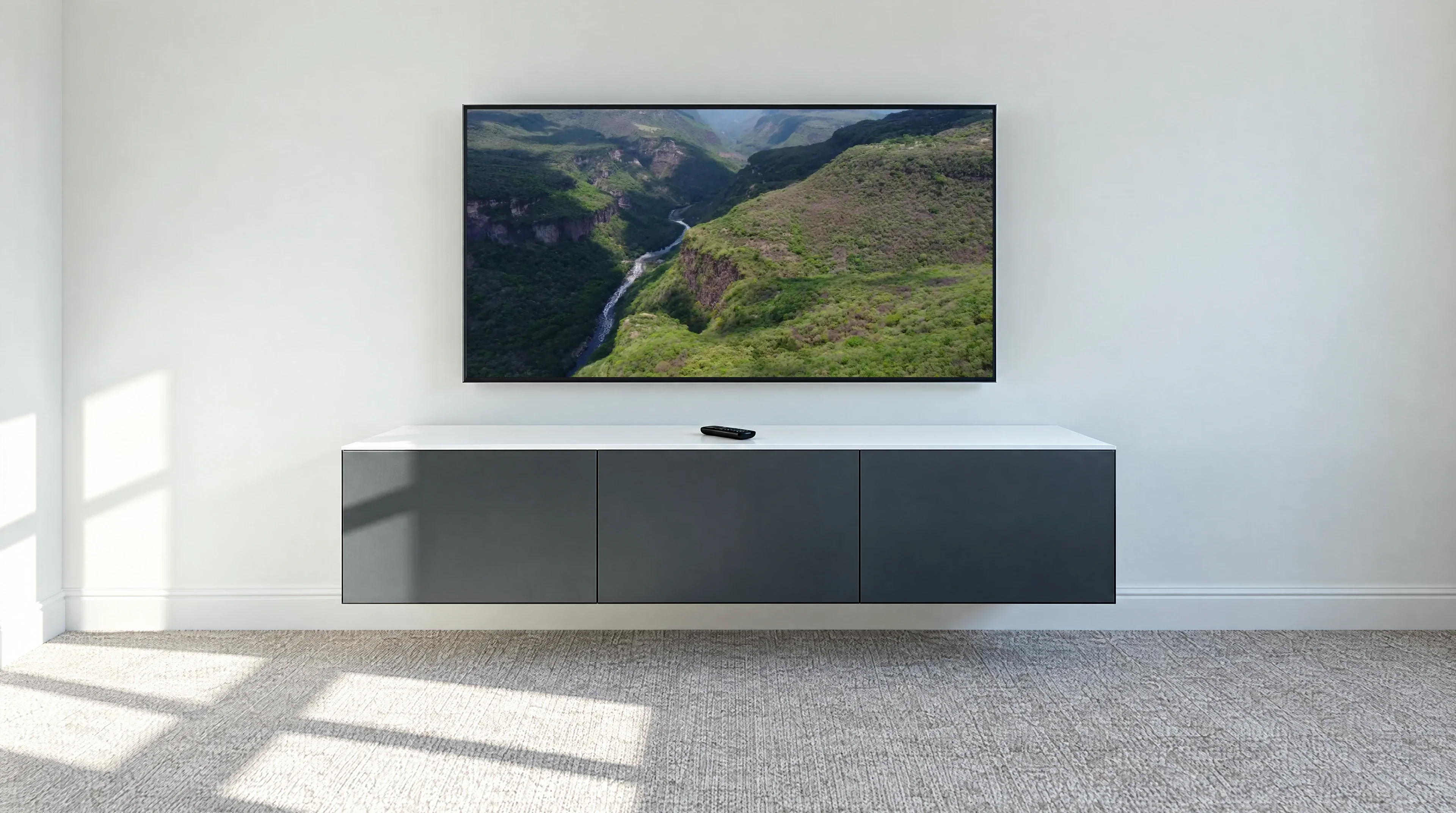 Large TV wall mounted above a floating grey media unit with no visible cables, Colchester