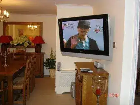 TV bracket fitting above fireplace with cables routed through the wall cavity