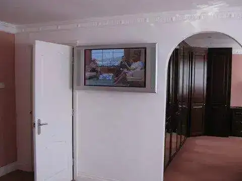 Screen mounted above built-in cabinets with cables dropped inside the unit